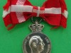 Kong Frederik IX belønningsmedalje med krone og sløjfe. 28x39 mm averse. 1947-1971. Nr. 207 i Stevnsborgs bog. Antal præget: 575