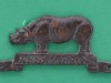 Cap badge, Assam Regiment, 1941-1947 Brass badge in the form of a rhinoceros over a scroll, with a unit tile, 'Assam Regt'.-39-x-19mm-1